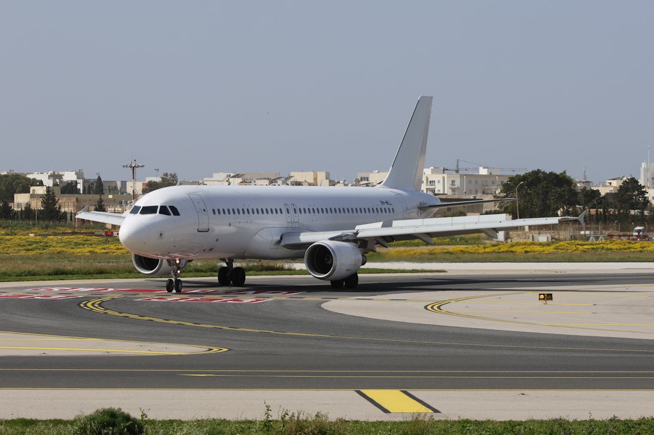 A commercial airplane on a runway preparing for takeoff at an airport.